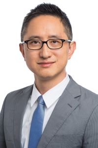 Photo Hao Wu wearing glasses and a gray suit with a white shirt. 